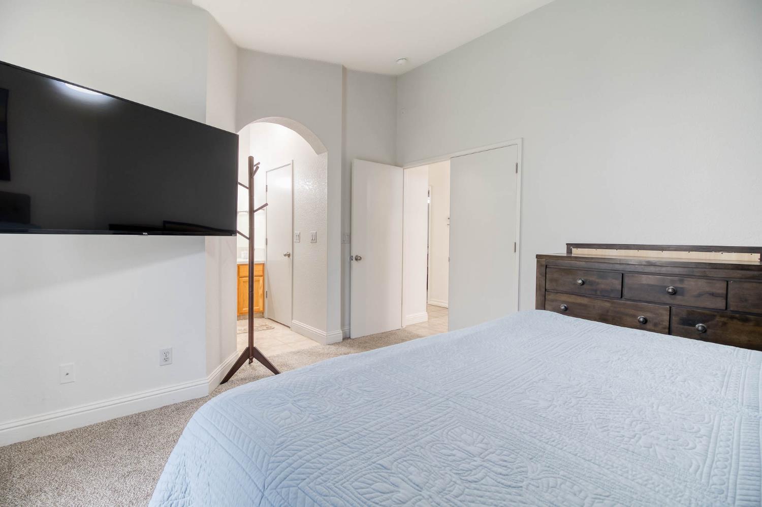 2913 Soquel Avenue Atwater, CA 95301 - Photo 22 of 29 a spacious bedroom with a bed and a flat screen tv