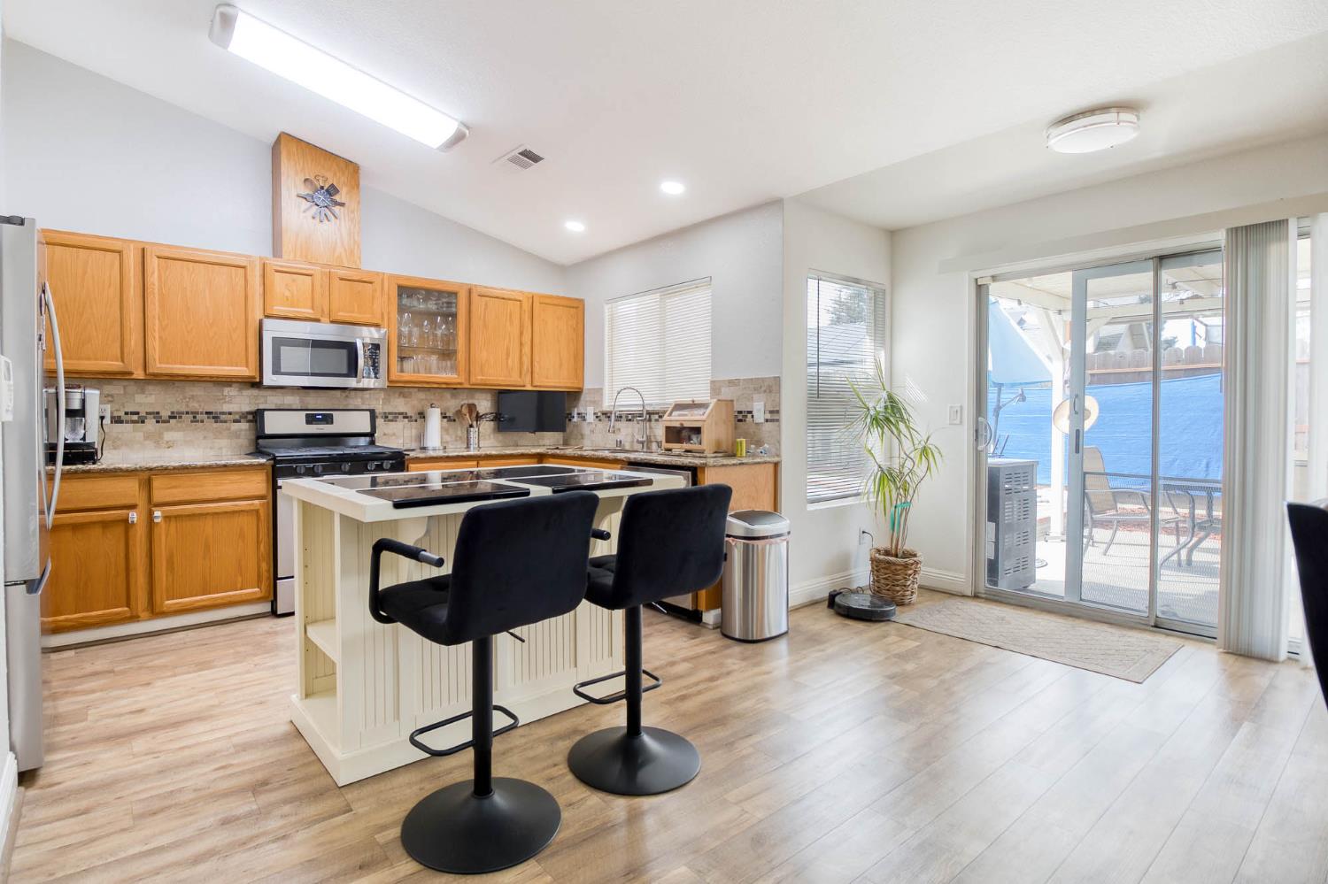 2913 Soquel Avenue Atwater, CA 95301 - Photo 10 of 29 a kitchen with stainless steel appliances granite countertop a stove a sink a refrigerator and a microwave