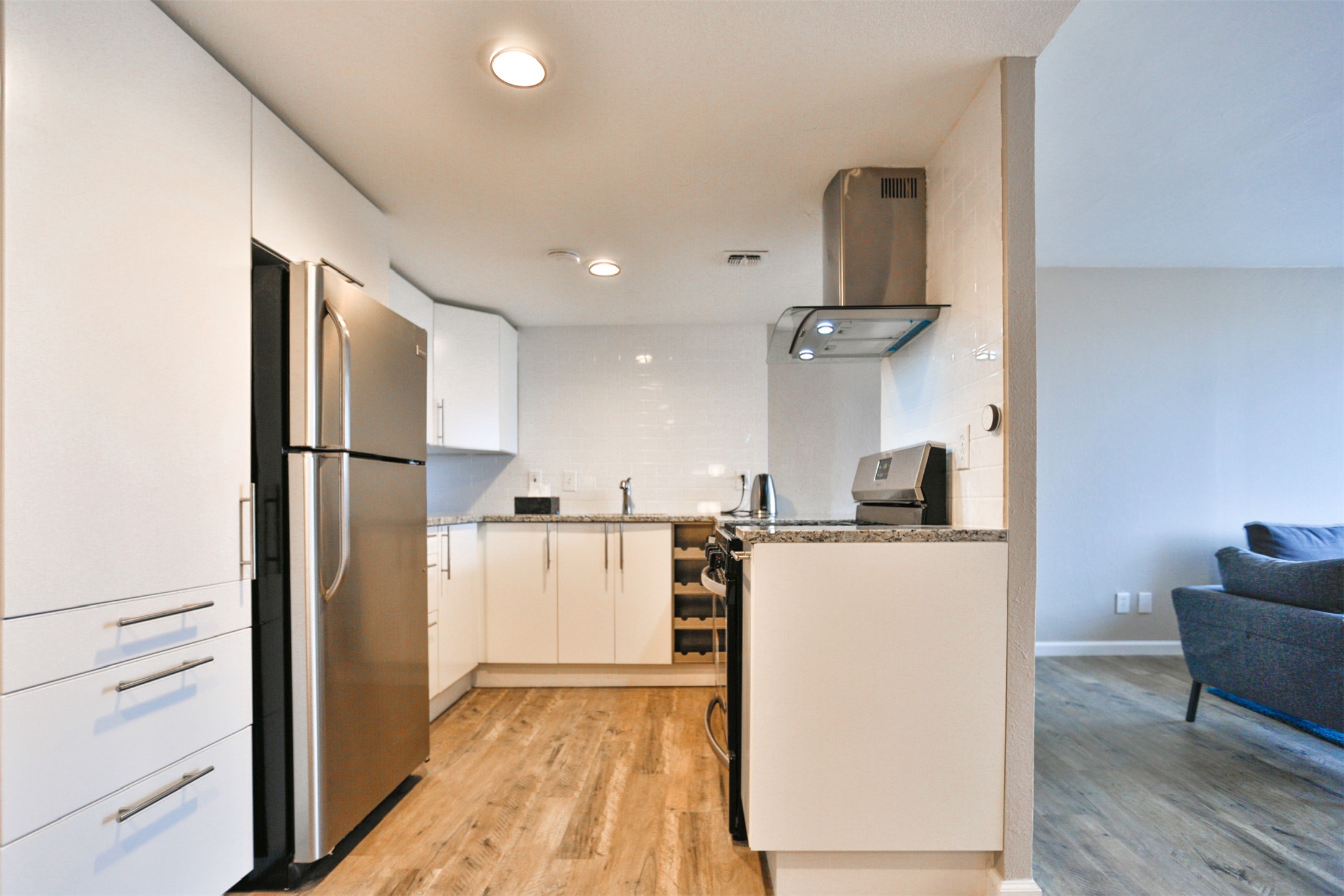 1800 Lavaca Street, Unit A608 Austin, TX 78701 - Photo 3 of 12 Kitchen featuring extractor fan, range with electric cooktop, freestanding refrigerator, white cabinets, and recessed lighting