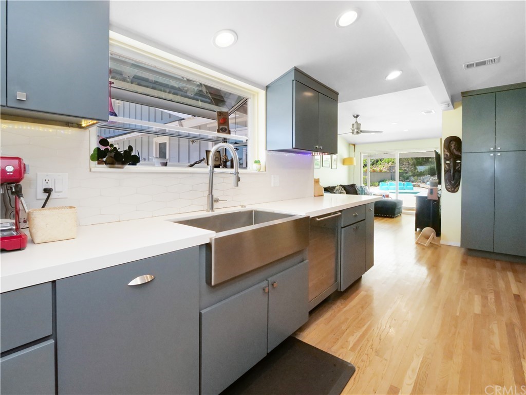 5063 Foxpoint Lane Rolling Hills Estates, CA 90274 - Photo 10 of 35 a large kitchen with stainless steel appliances a sink dishwasher a refrigerator and a dining table with wooden floor