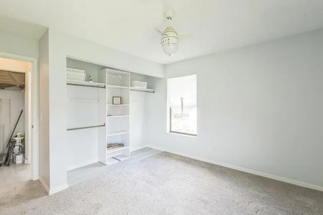 a view of a kitchen with refrigerator and white cabinets
