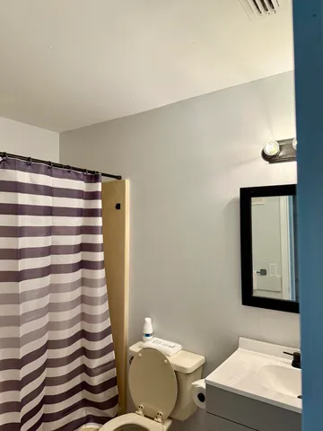 a bathroom with a sink a toilet and mirror