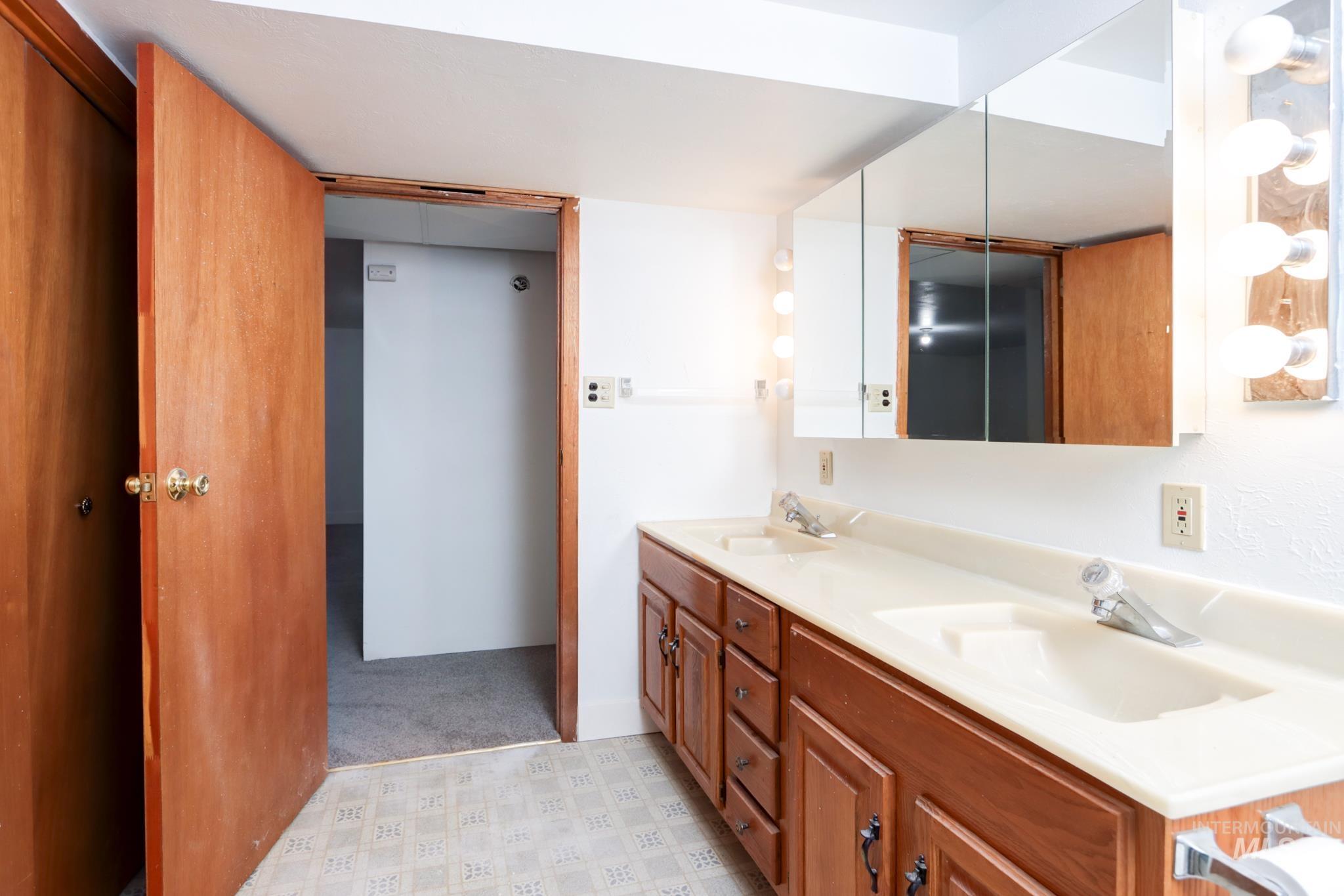 801 Thompson Avenue Nyssa, OR 97913 - Photo 33 of 46 Bathroom featuring a dual vanity with integrated sinks, wood-finish cabinetry, and a mirrored medicine cabinet