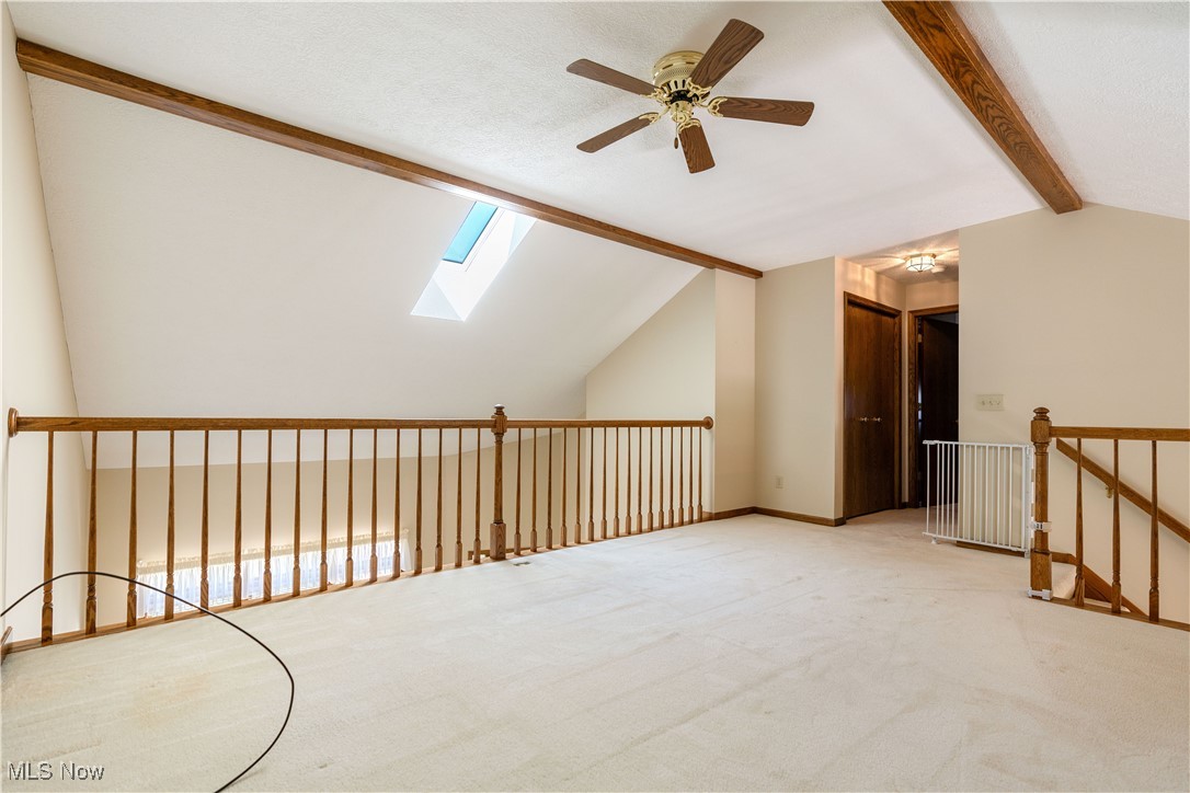 2603 Charing Cross Road Northwest Canton, OH 44708 - Photo 15 of 24 Additional living space featuring light colored carpet, ceiling fan, and lofted ceiling with skylight