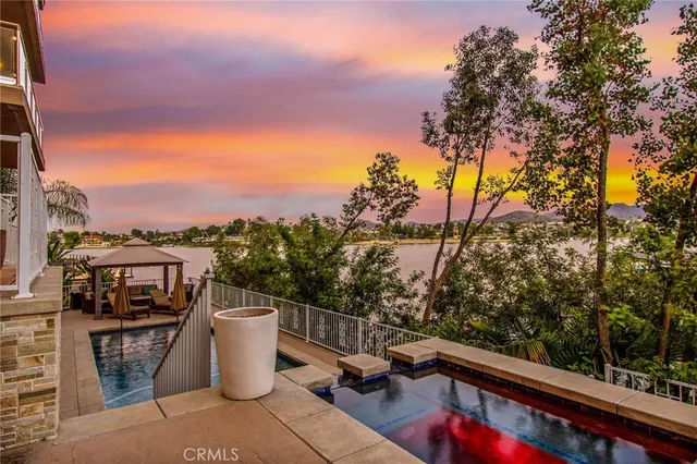 a dining room with wooden floor a chandelier a wooden table and chairs