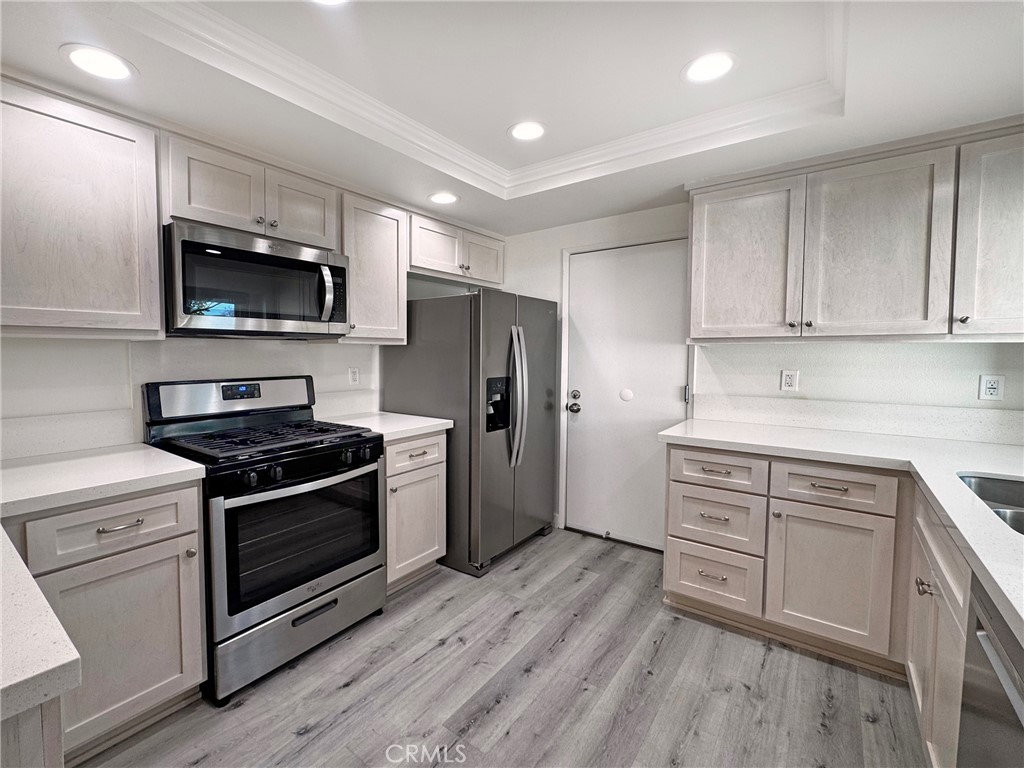 a kitchen with stainless steel appliances white cabinets and a stove top oven