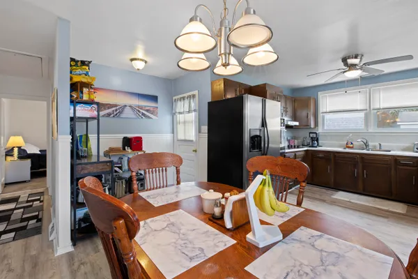 a dining room with furniture a chandelier and wooden floor