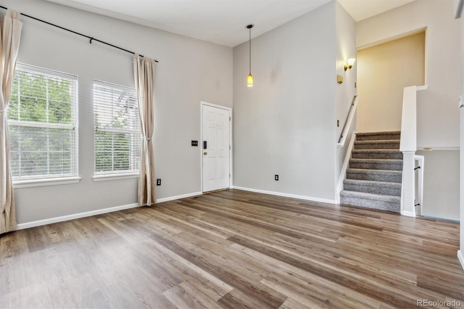 9773 Saybrook Street Highlands Ranch, CO 80126 - Photo 2 of 21 a view of an empty room with wooden floor and a window