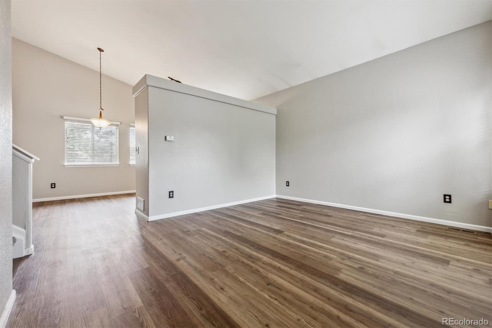 9773 Saybrook Street Highlands Ranch, CO 80126 - Photo 3 of 21 a view of an empty room with wooden floor and a window