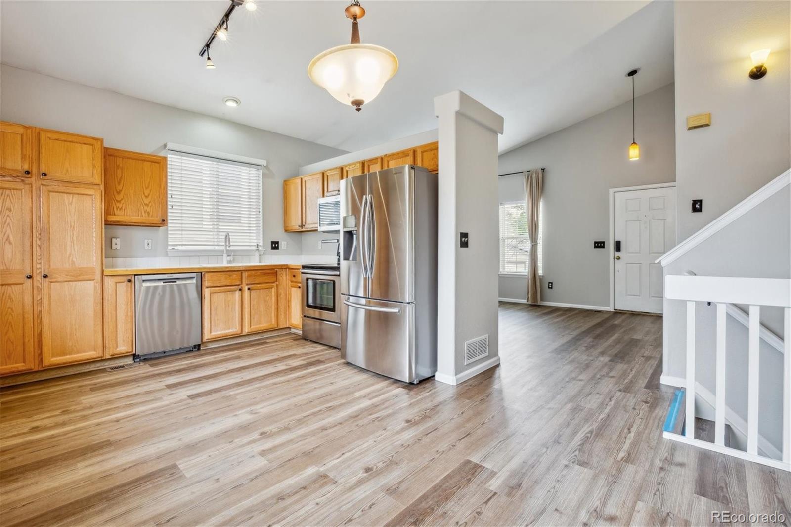 9773 Saybrook Street Highlands Ranch, CO 80126 - Photo 5 of 21 a kitchen with stainless steel appliances granite countertop a refrigerator a oven a stove and a wooden floors