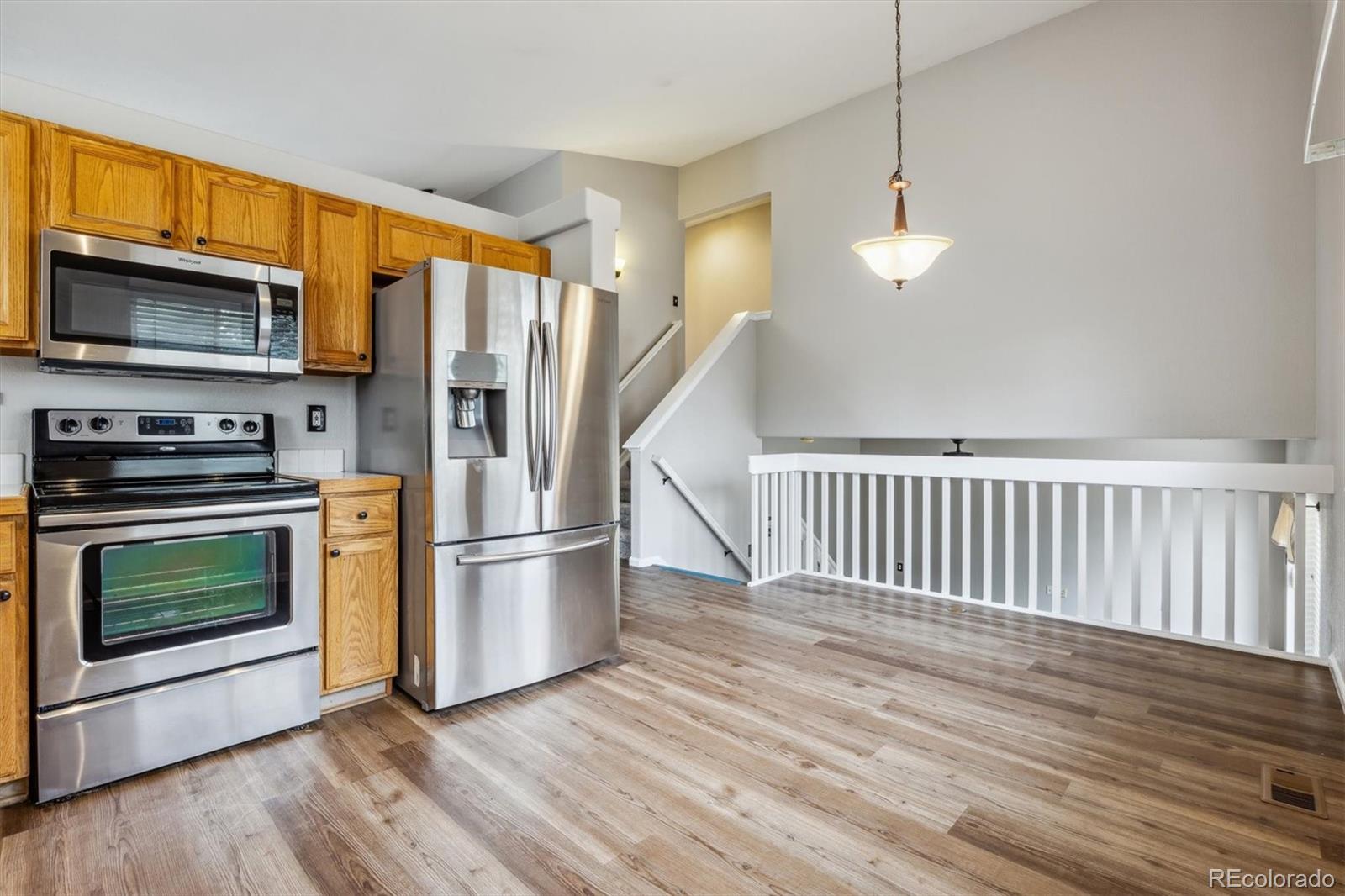9773 Saybrook Street Highlands Ranch, CO 80126 - Photo 6 of 21 a kitchen with stainless steel appliances a stove a refrigerator and a microwave