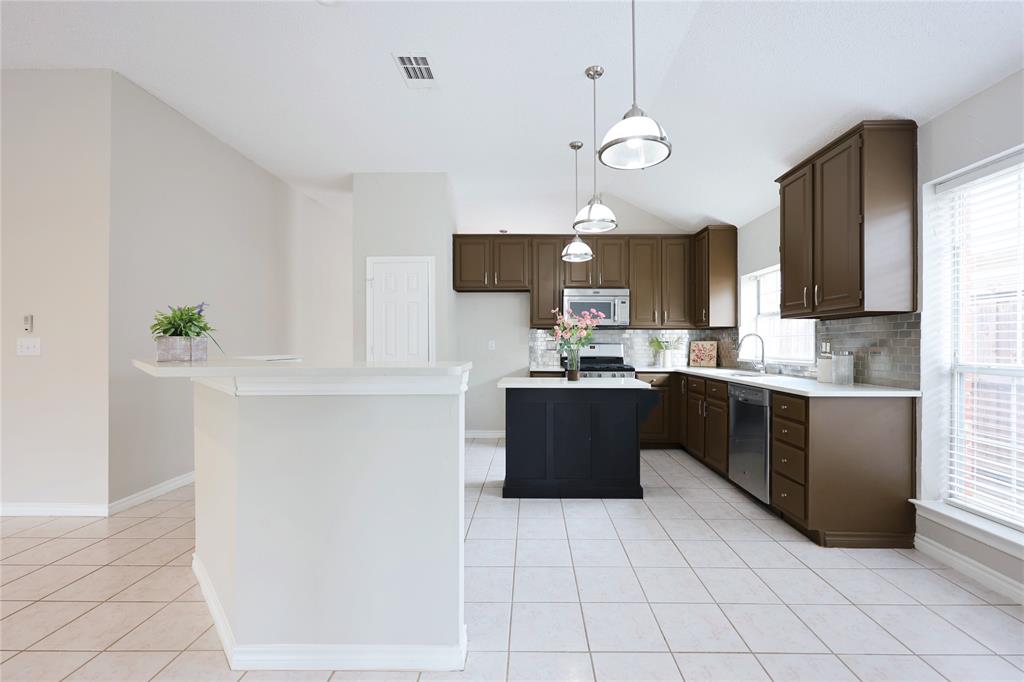 8112 Dock Street Frisco, TX 75035 - Photo 15 of 34 a kitchen with granite countertop a refrigerator a stove top oven a sink and dishwasher