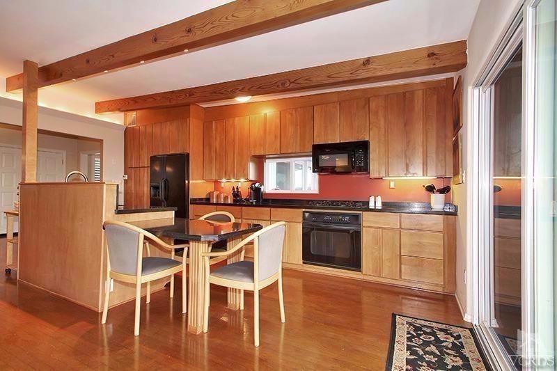 520 San Clemente Way Camarillo, CA 93010 - Photo 7 of 49 a kitchen with stainless steel appliances kitchen island granite countertop a refrigerator a stove a microwave oven with a dining table and chairs with wooden floor