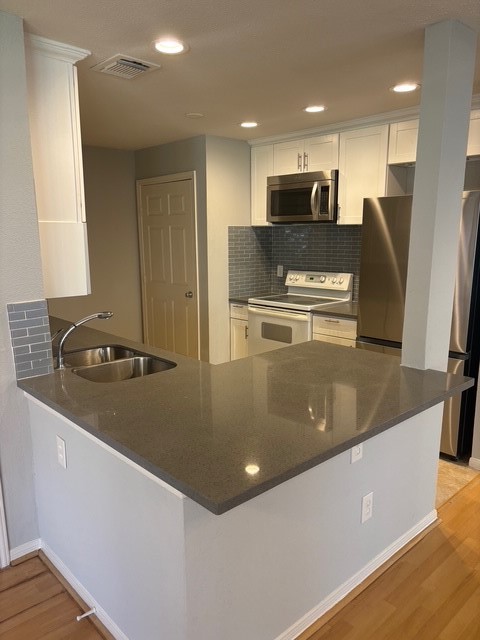 2211 South Kirkwood Road, Unit 22 Houston, TX 77077 - Photo 6 of 15 a kitchen with stainless steel appliances granite countertop a refrigerator a stove and a sink with wooden floor