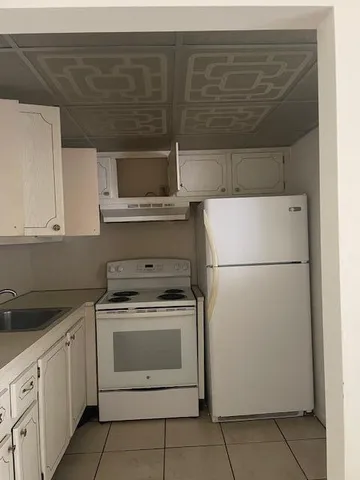 a kitchen with cabinets a refrigerator and a sink
