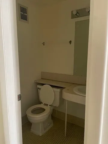 a white toilet sitting next to a shower