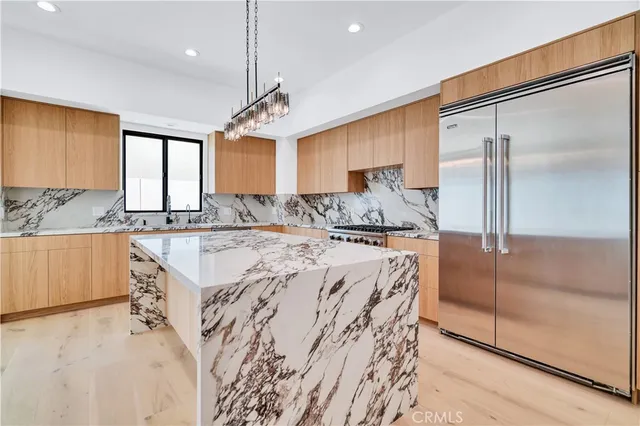 a kitchen with stainless steel appliances granite countertop a sink a refrigerator and a granite counter tops