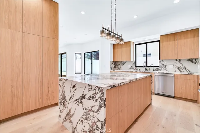 a kitchen with granite countertop a sink window and cabinets