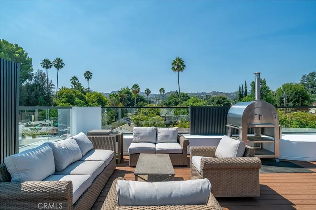 a view of a patio with a table and chairs under an umbrella with wooden floor and fence