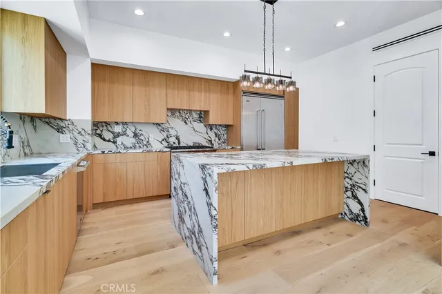 a kitchen with kitchen island granite countertop a sink a counter top space and cabinets