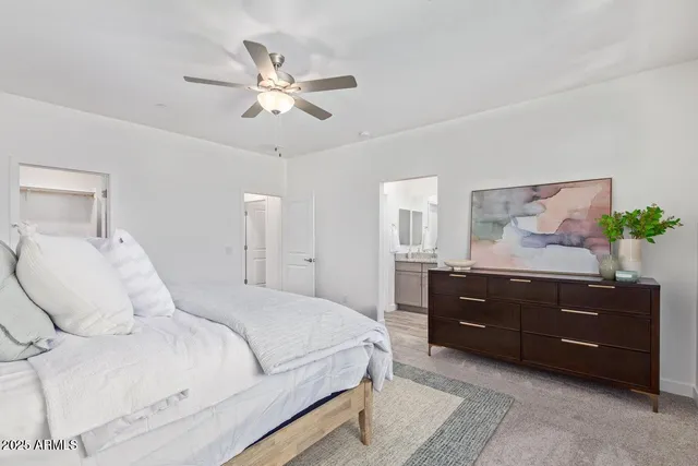 a bedroom with a bed and lamp on dresser