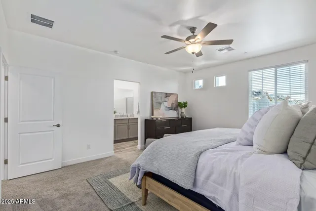 a bedroom with a large bed and a chandelier