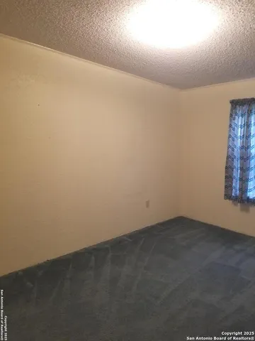a view of an empty room with a wooden shelves