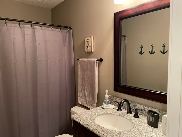a bathroom with a granite countertop sink and a mirror