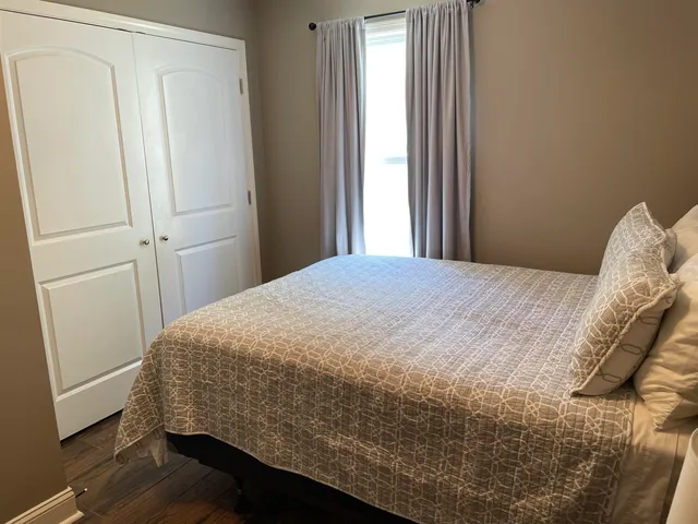 a bed sitting in a bedroom next to a window