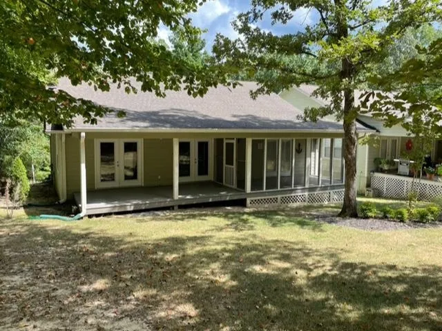 a view of a house with a large tree in front of it