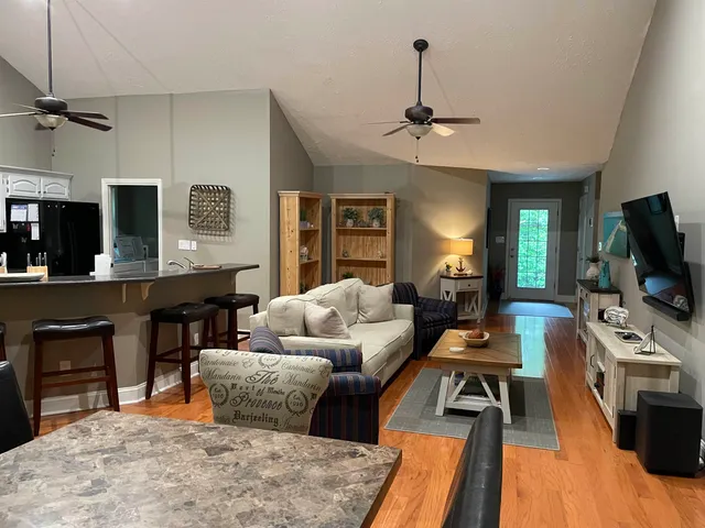 a living room with furniture a chandelier and a flat screen tv
