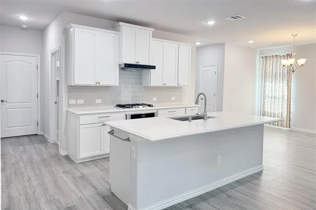 a kitchen with stainless steel appliances a sink stove and cabinets