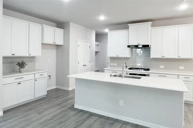 a kitchen with stainless steel appliances sink stove refrigerator and cabinets