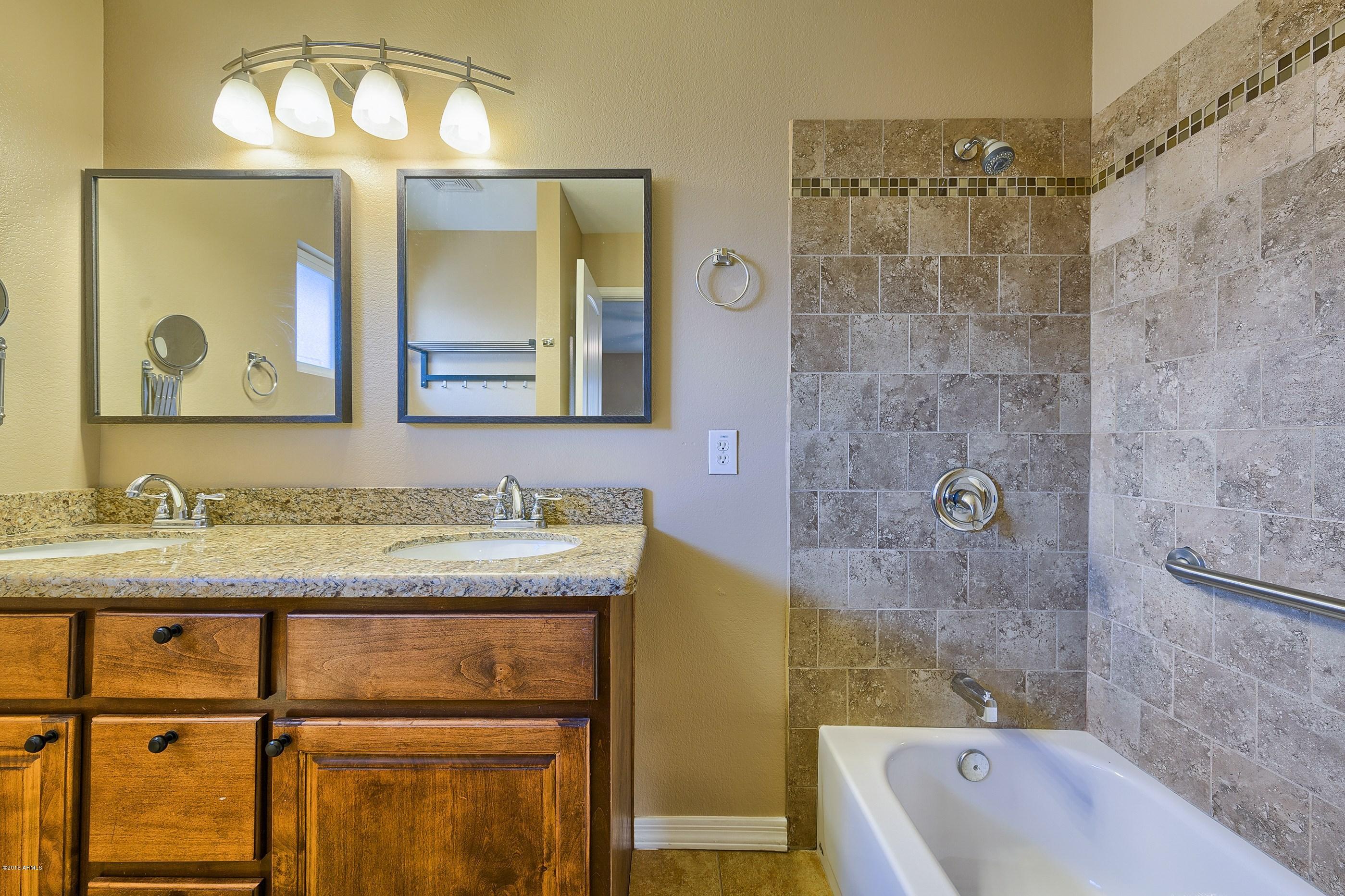 1601 North 13th Avenue Phoenix, AZ 85007 - Photo 9 of 18 a bathroom with a granite countertop sink a mirror a bathtub and shower