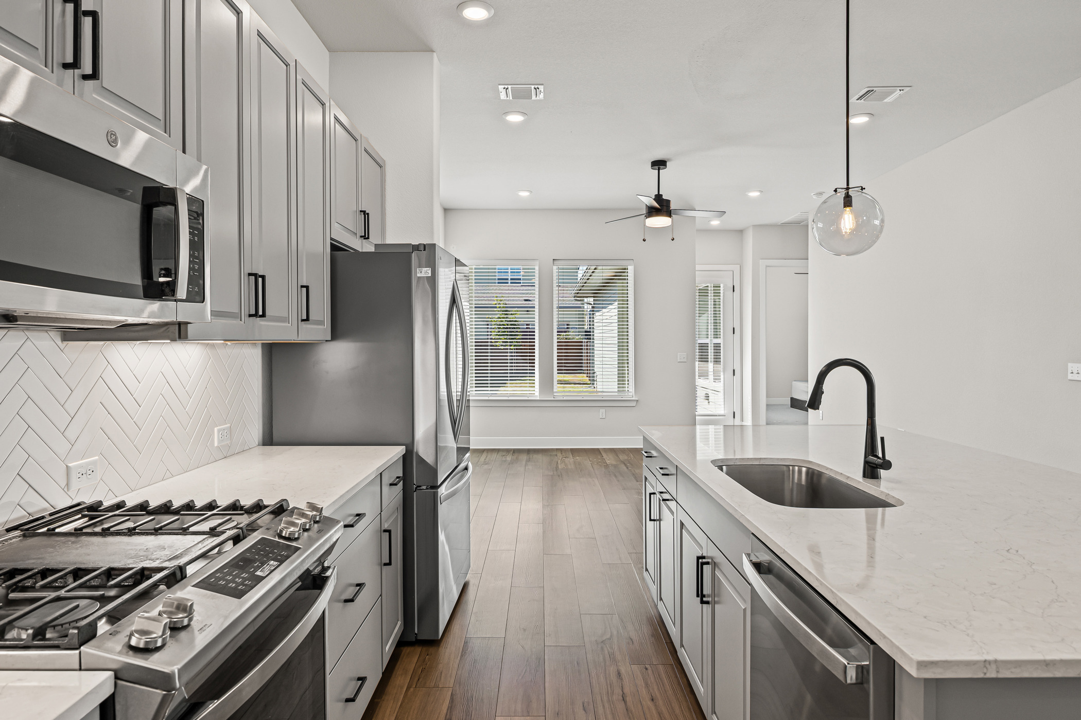 a kitchen with stainless steel appliances granite countertop a sink a stove and a refrigerator