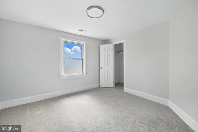 an empty room with windows and closet