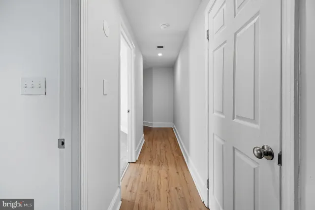 a view of a hallway with wooden floor and staircase