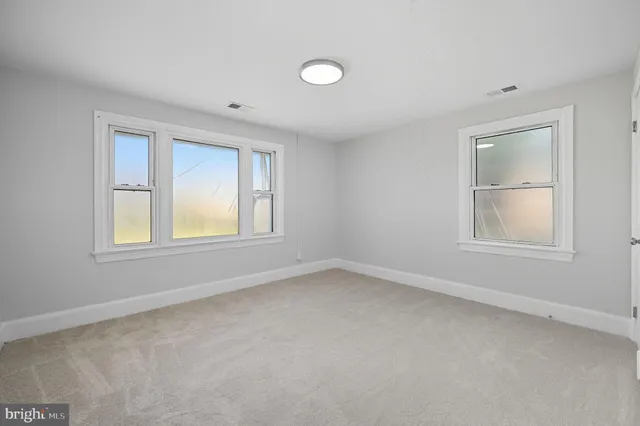 an empty room with windows and closet