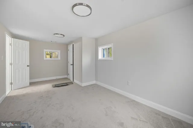 an empty room with windows and closet