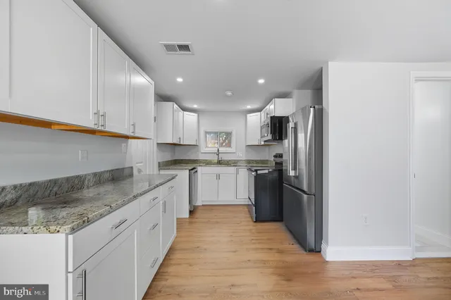 a kitchen with stainless steel appliances granite countertop a refrigerator sink and cabinets