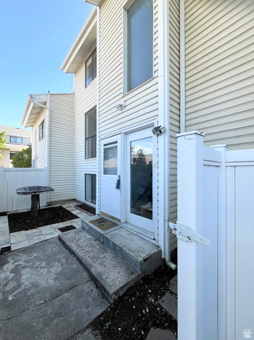 227 South West Lane Provo, UT 84601 - Photo 2 of 25 White vinyl siding exterior with an upper-level large picture window and a ground-level glass-paneled entry door