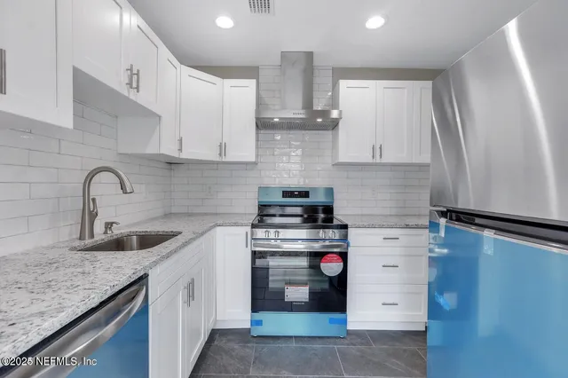 a kitchen with stainless steel appliances granite countertop a sink stove and refrigerator