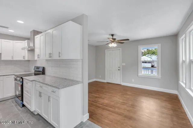 a kitchen with granite countertop white cabinets and white appliances