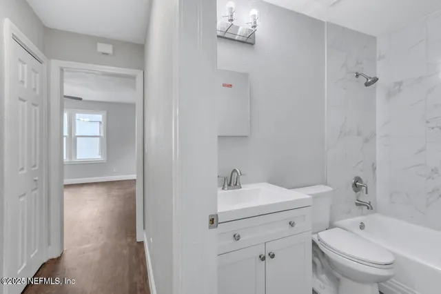 a bathroom with a toilet sink vanity shower and mirror