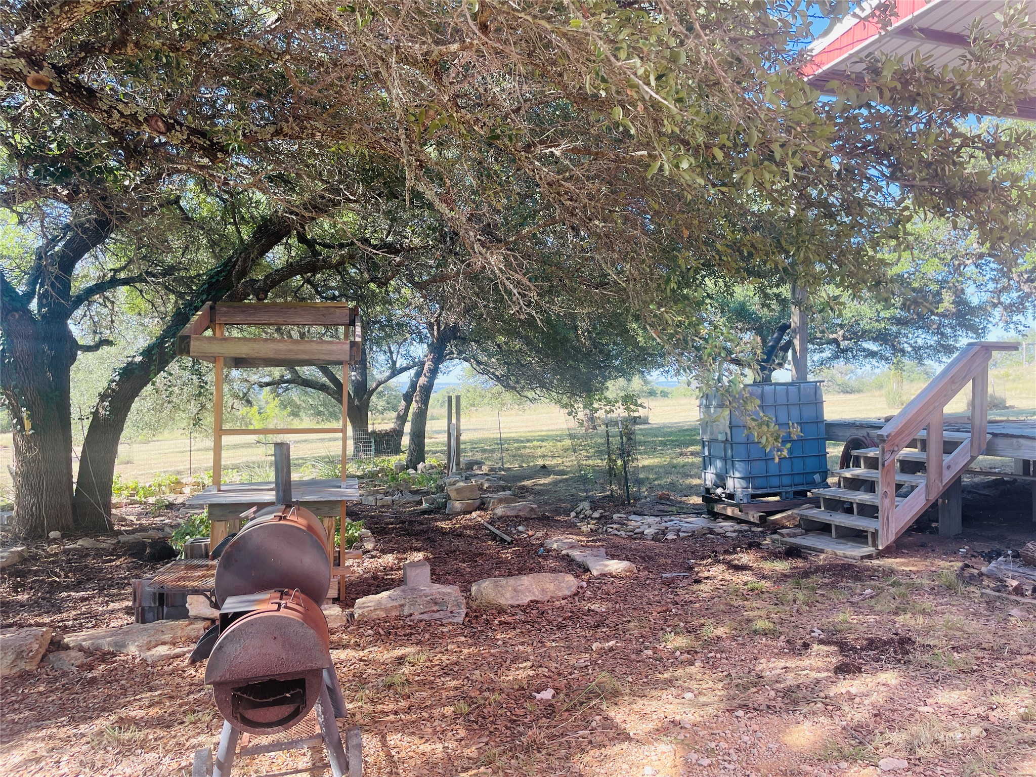 428 Summit Spring Lane Johnson City, TX 78636 - Photo 6 of 19 a backyard of a house with barbeque oven table and chairs