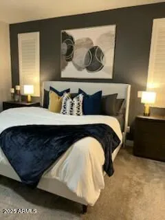 a bedroom with a bed and painting on the wall