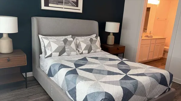 a bedroom with a bed lamp and a window