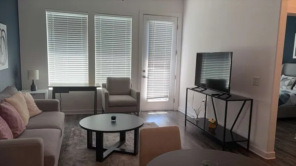 a living room with furniture a window and a flat screen tv