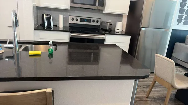 a kitchen with stainless steel appliances kitchen island a refrigerator sink and stove