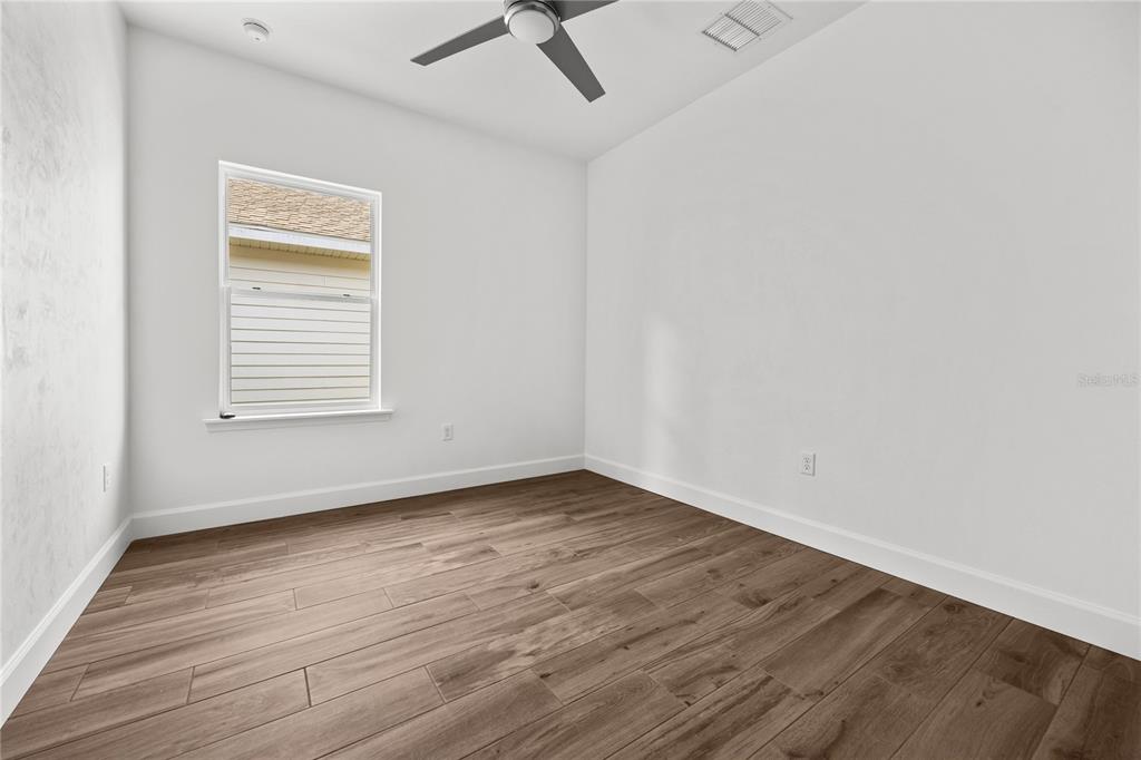 1086 Southwest 67th Drive Gainesville, FL 32607 - Photo 30 of 37 an empty room with wooden floor and windows